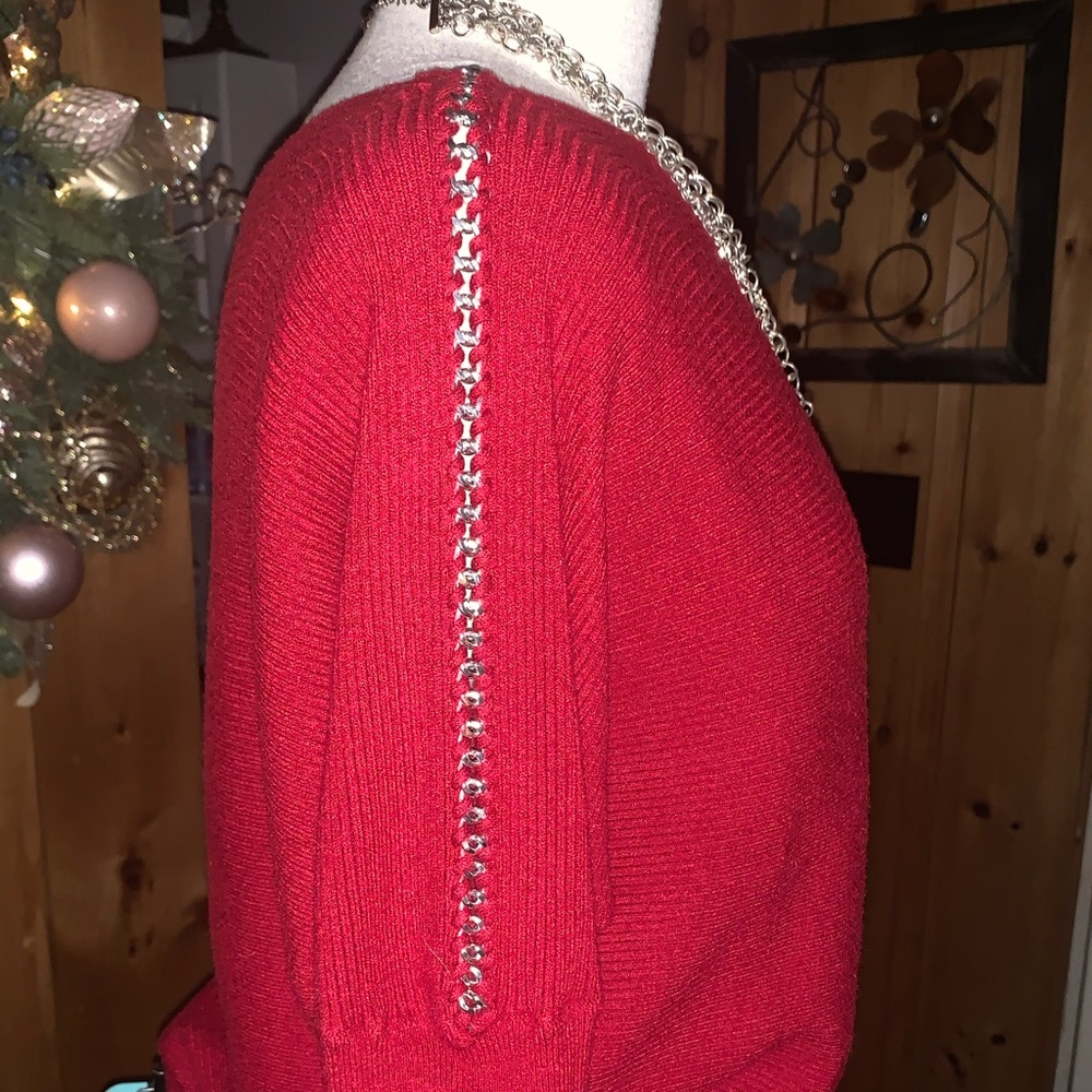 Jennifer Lopez sweater with chain detail down sleeve.